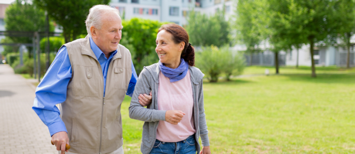 Senior Walking With Caregiver Outside