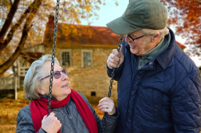 senior couple standing by a swing