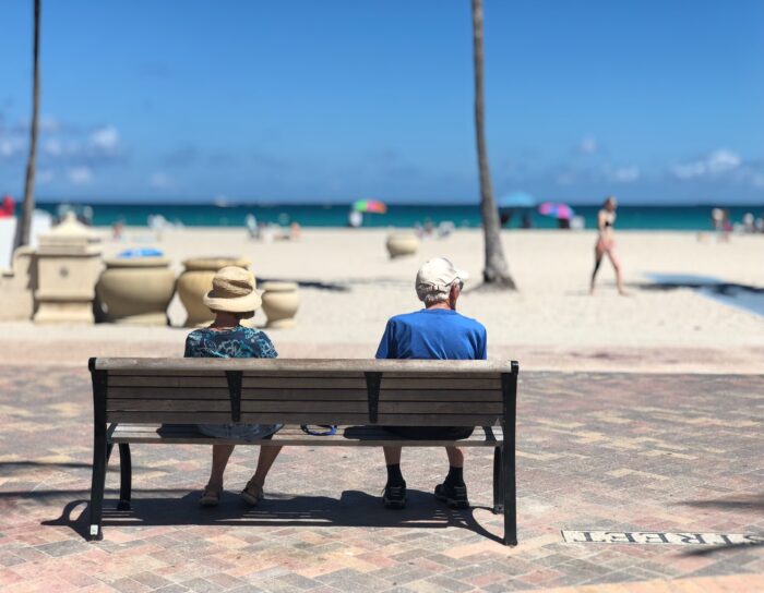 seniors siting on a bench at the beach