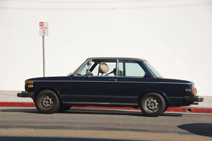 senior driving a vintage car