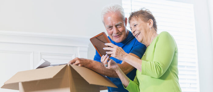 elderly couple packing their items while downsizing for senior living