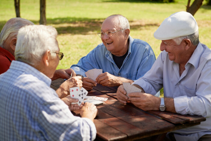 senior living residents playing cards outside