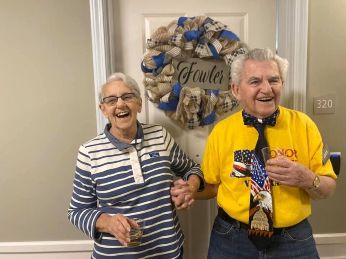 senior living residents holding hands and laughing