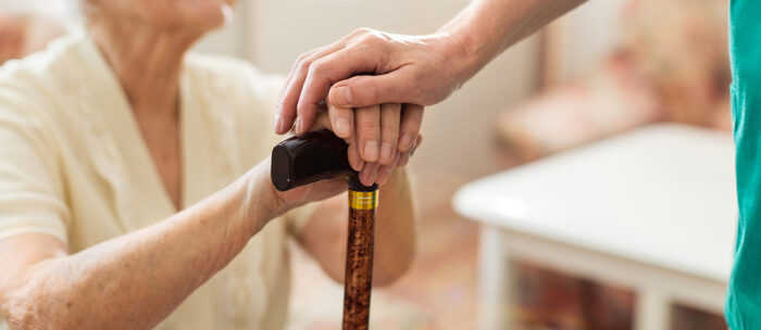 caregiver holding hands with a senior living resident
