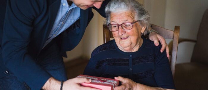 adult son gifting his mother a care package