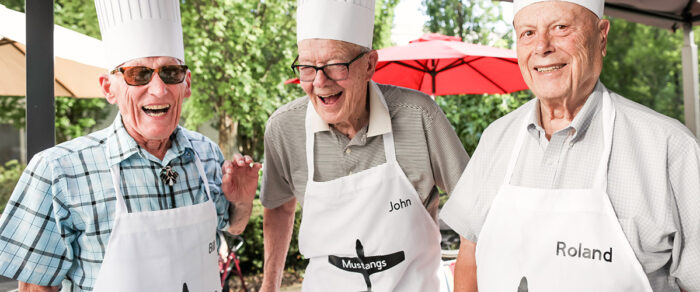 senior living residents grilling together