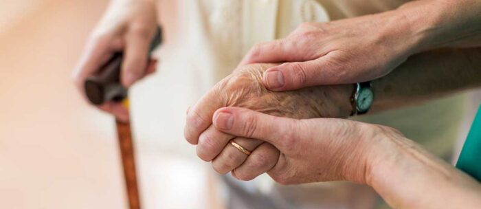 caregiver holding a seniors hand