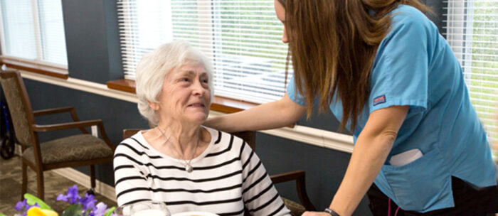 Caregiver helping senior woman