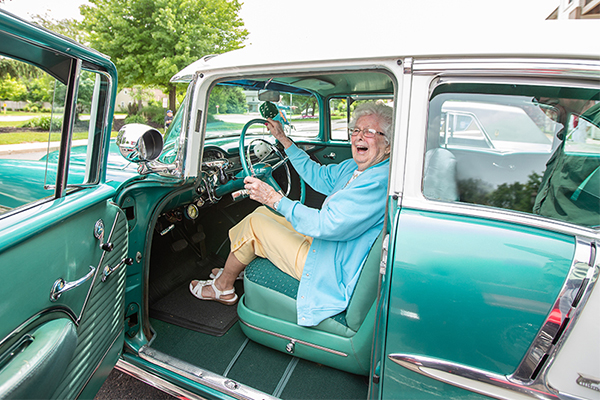 senior woman in blue classic car