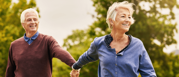 senior couple walking outside holding hands