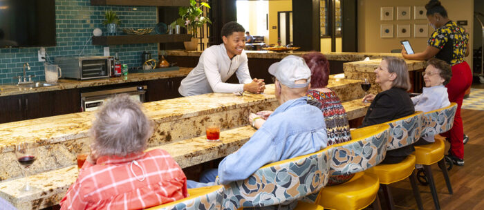 seniors sitting at bar with smiling bartender