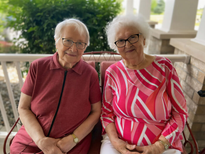 two senior women sitting on a patio