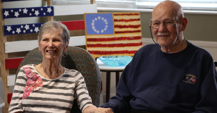 seniors sitting in front of American flags