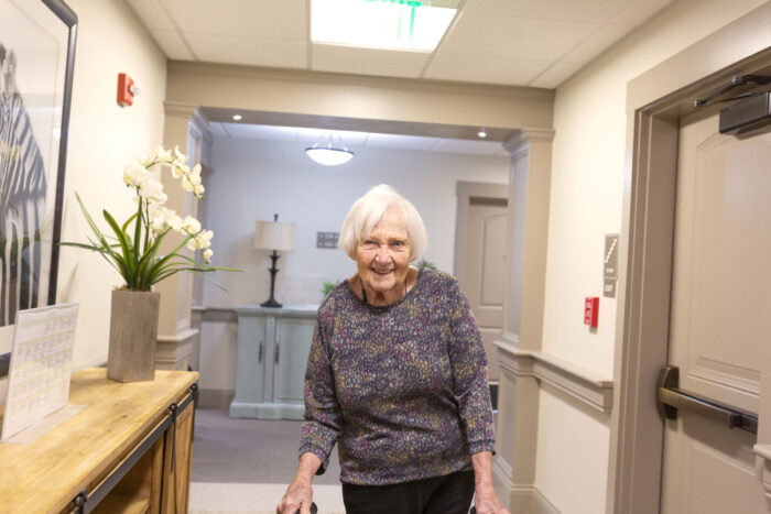 Elderly woman smiling in hallway