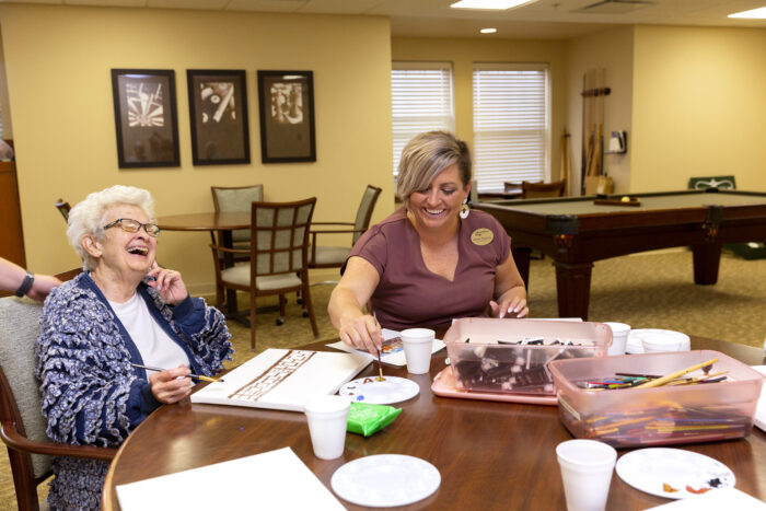 senior woman laughing with caregiver