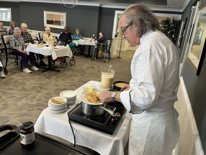 elderly man cooking at an omlet station