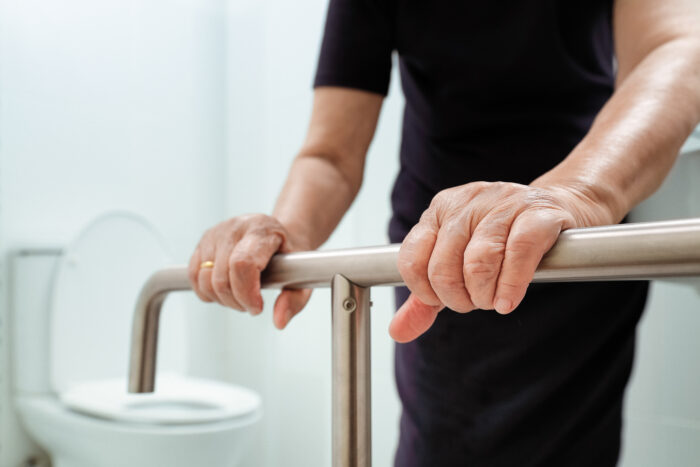 Senior holding a handrail in bathroom