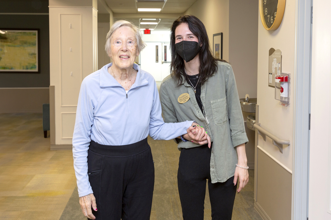 StoryPoint caregiver holding a residents hand