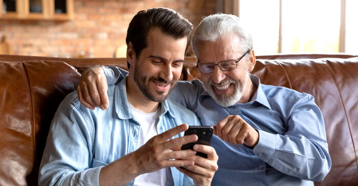 senior and son using smartphone