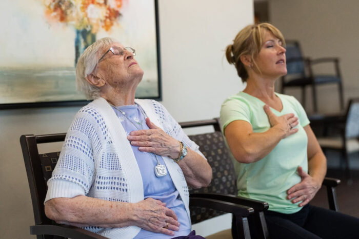 senior woman and caregiver meditating