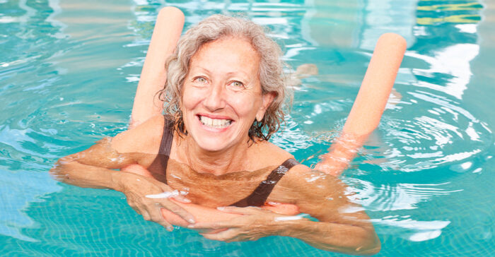 senior woman swimming with pool noodle