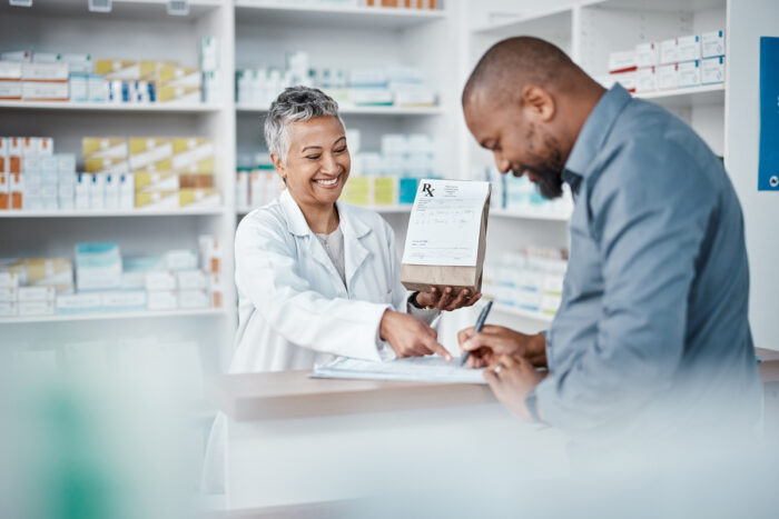 adult picking up a prescription at pharmacy