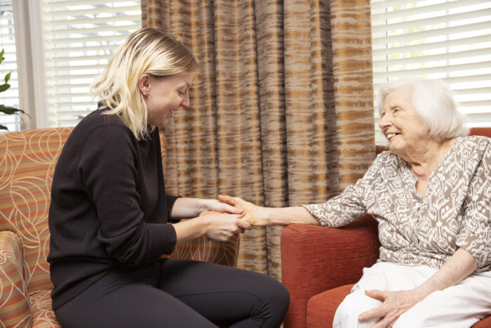 caregiver holding hand of senior woman