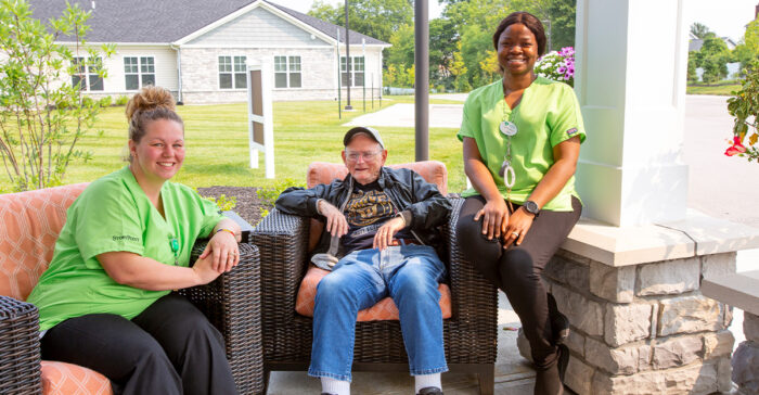 senior man and caregivers sitting outside