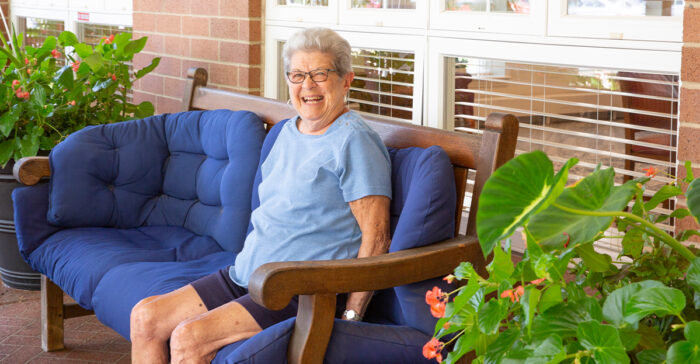 senior woman sitting outside smiling