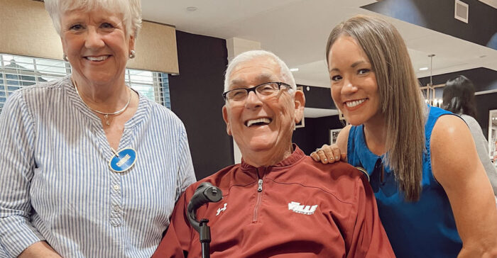 smiling resident with two caregivers