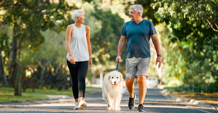 senior couple walking their dog