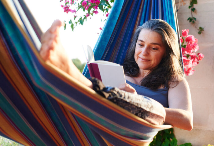 senior woman reading in a hammock