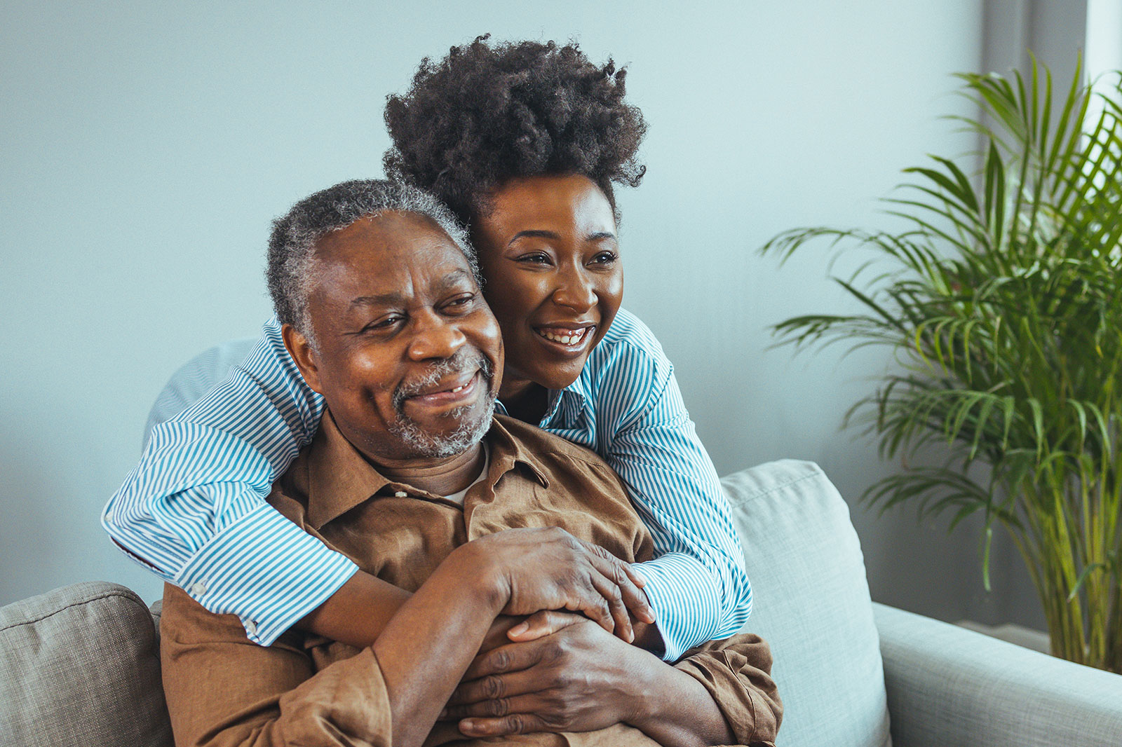 daughter and father hugging on a sofa