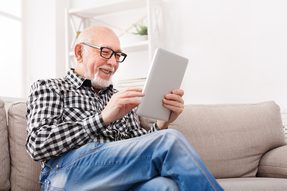 senior on the couch using a tablet