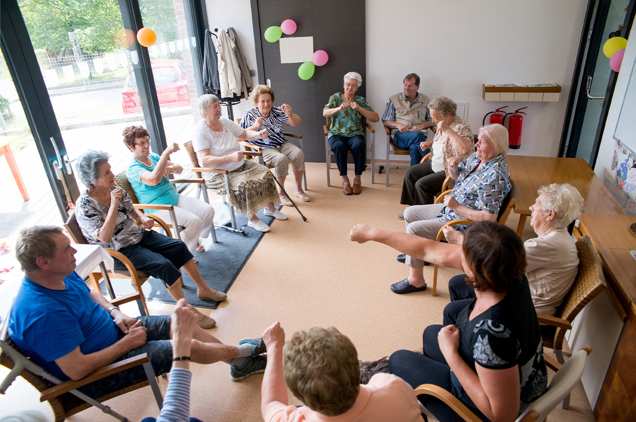 seniors sitting in a circle at a birthday party telling stories