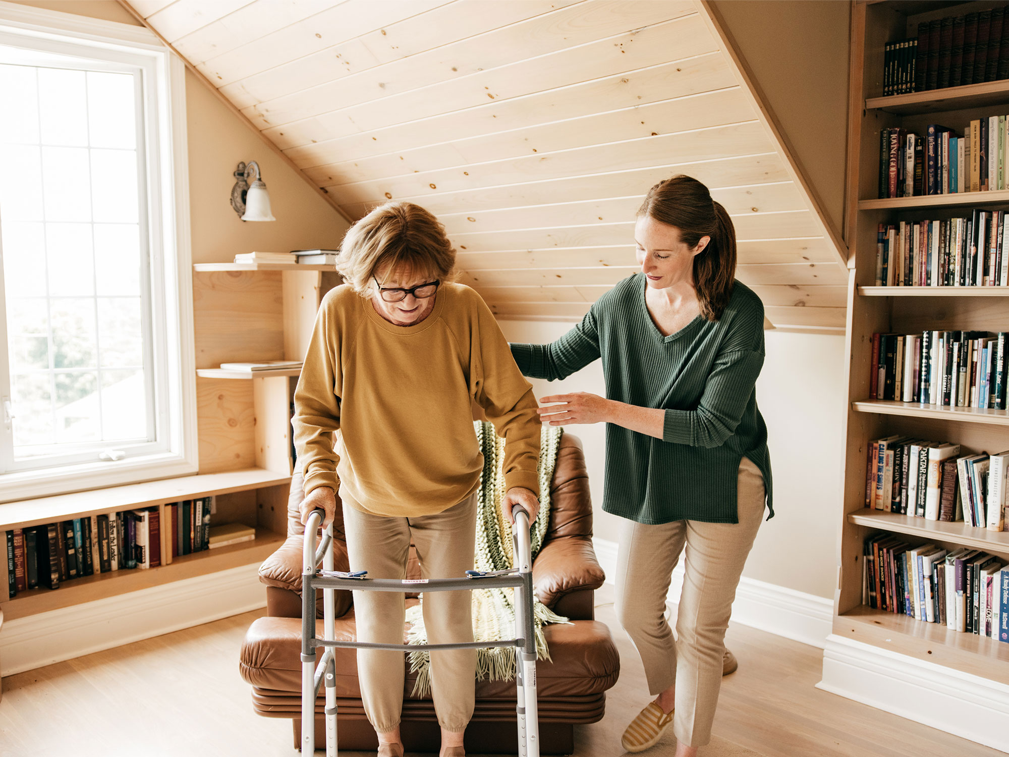daughter helping senior mother with walker